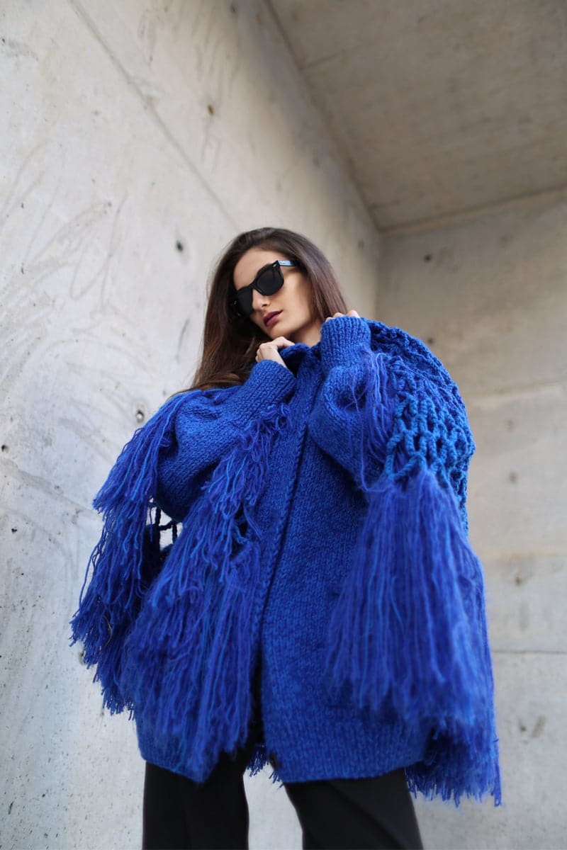 Blikvanger fringed poncho-style cardigan with open front and textured fabric, displayed on a neutral background.