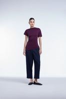 Dāl the Label asymmetrical short sleeve top in soft fabric, featuring unique hemline and modern design, worn by a model against a neutral background.