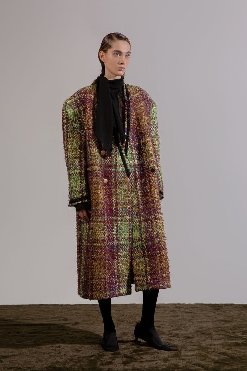 Lalo oversized brown tweed coat hanging on a wooden hanger, showcasing its textured fabric and relaxed fit style.