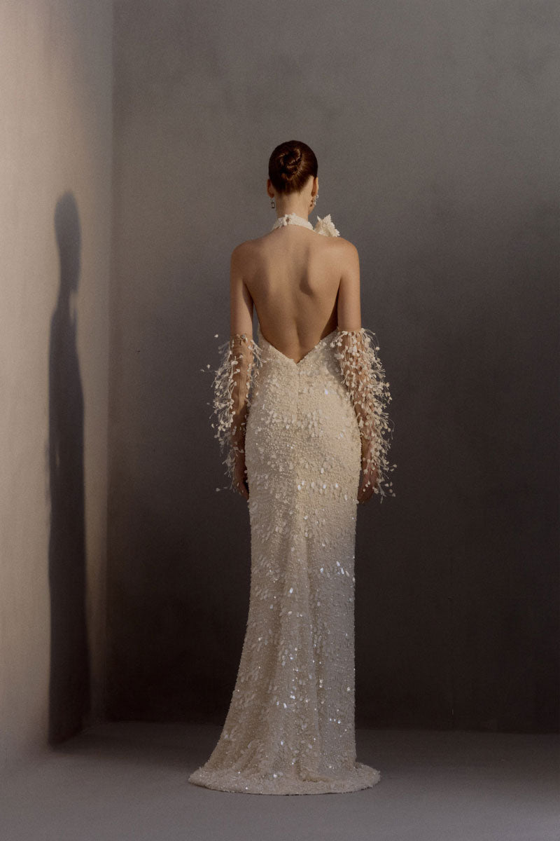 White Plan chiffon gown displayed on a hanger, flowing fabric with delicate pleats, elegant evening dress for formal occasions.