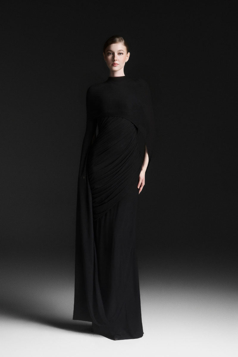 Black CELIORA cape sleeve floor-length maxi dress by Maison Des Copains, featuring elegant flowing fabric and dramatic cape sleeves.