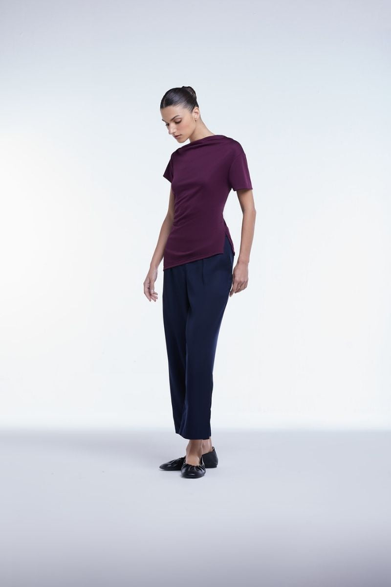 Dāl the Label asymmetrical short sleeve top with uneven hem, lightweight fabric, and modern design, shown on a model.