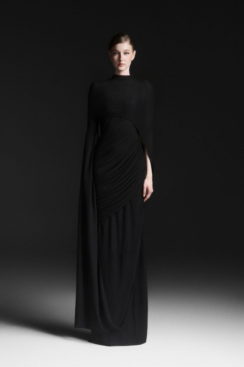 Black Maison Des Copains Celiora cape sleeve floor-length maxi dress displayed on a model. Elegant evening wear with flowing fabric.