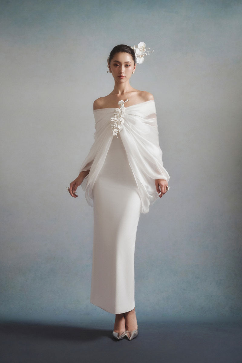 White Plan ELYSIA draped midi dress with flowing fabric and elegant design, shown on a model in a stylish setting.