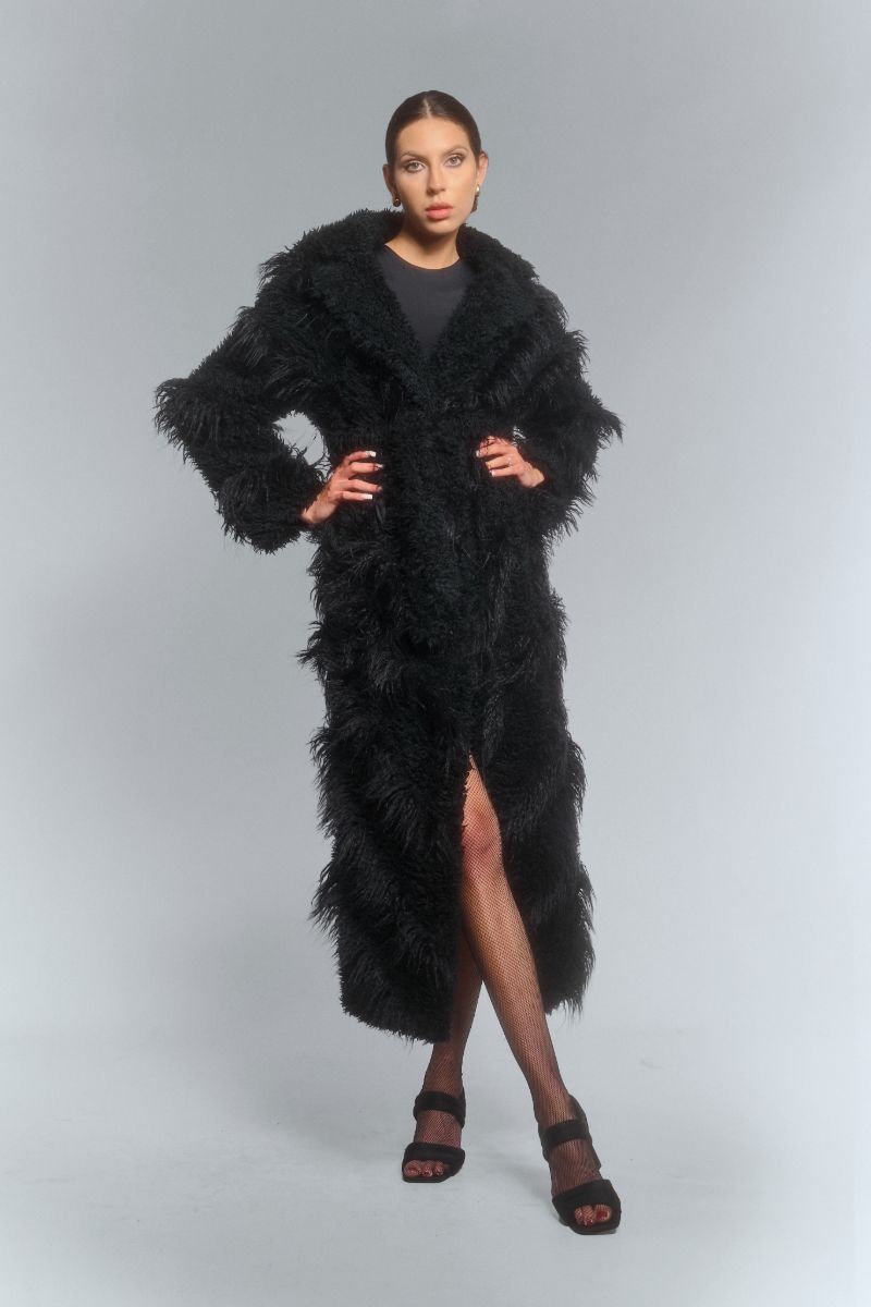 Black faux fur maxi coat with diagonal panel design by Fortini, featuring a plush texture and elegant silhouette.
