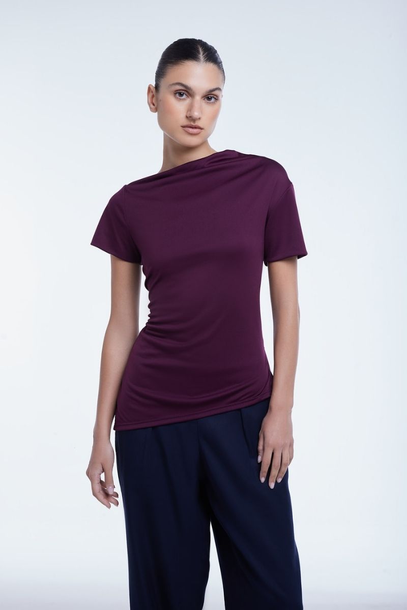 Dāl the Label asymmetrical short sleeve top with stylish draped design, lightweight fabric, and modern silhouette.