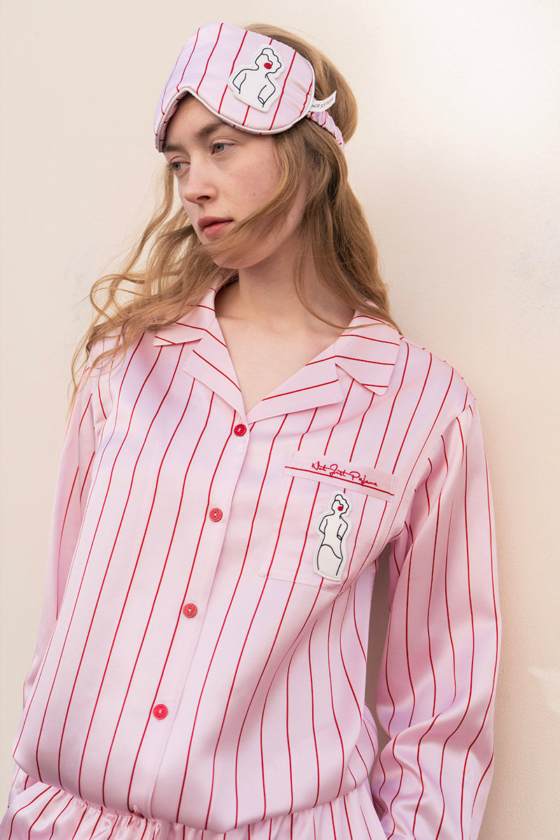 Pink and white striped silk pajama set from Not Just Pajama's Museum of Crush collection, featuring long sleeves and matching pants.