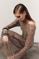Nazlı Ceren Riona maxi dress in antique bronze, flowing fabric with elegant design, displayed on a mannequin.