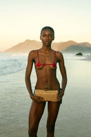 Waiwai Rio rattan sardine clutch bag with woven texture and rounded design, featuring a compact and stylish look.