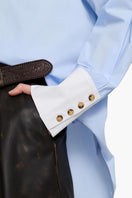Acaria Studio iconic French Blue shirt featuring a classic fit, long sleeves, and button-up front displayed on a hanger.