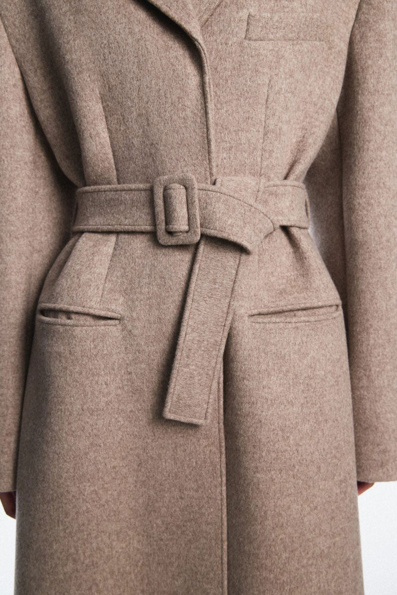 Chictopia belted long line coat in neutral fabric with a tailored fit and classic collar, perfect for stylish winter wear.