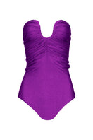 Purple Laura Escobar Serrania one-piece swimsuit with stylish cutouts, shown on a model against a neutral background.