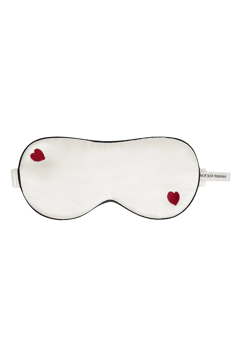 White Little Heart Eye Mask from Not Just Pajama, soft loungewear sleep mask with heart-shaped eye openings and comfortable fabric.
