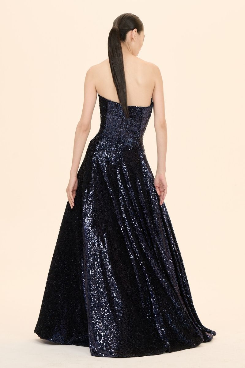 Nihan Peker Vertigo strapless gown with elegant draped design, fitted bodice, and flowing skirt for formal occasions.