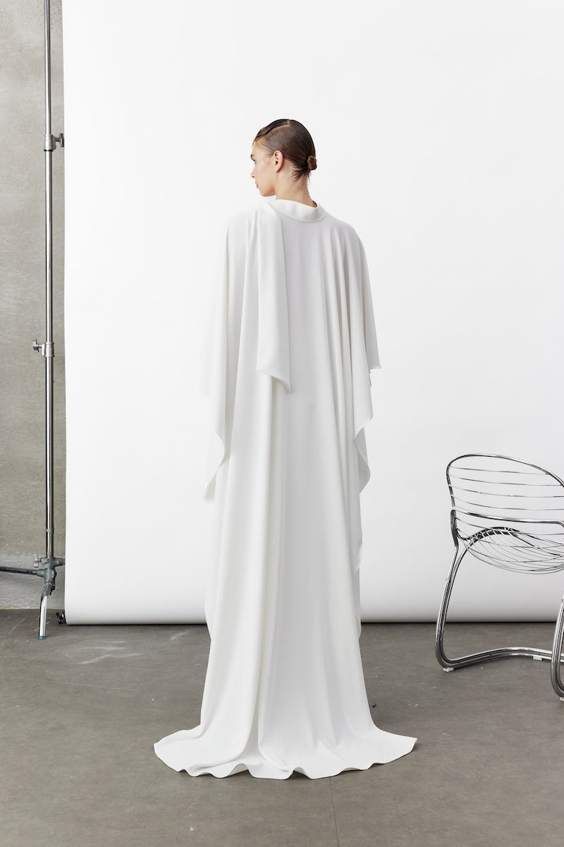 White Caro Crepe Cape jacket by Nazlı Ceren, showcasing flowing crepe fabric and elegant drape on a neutral background.