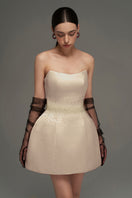 Beige I.H.F Studio bustier mini dress displayed on a hanger, showcasing its fitted design and stylish detailing.
