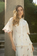 Estefania ivory tulip shirt featuring a fitted design with a V-neck and long sleeves, displayed on a hanger.