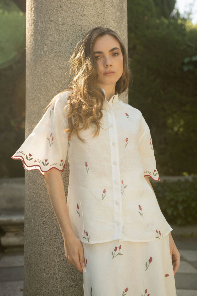 Estefania ivory tulip shirt featuring a fitted design with a V-neck and long sleeves, displayed on a hanger.