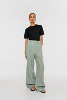 Dāl the Label linen wide leg pants in natural beige, featuring a relaxed fit and flowing silhouette on a neutral background.