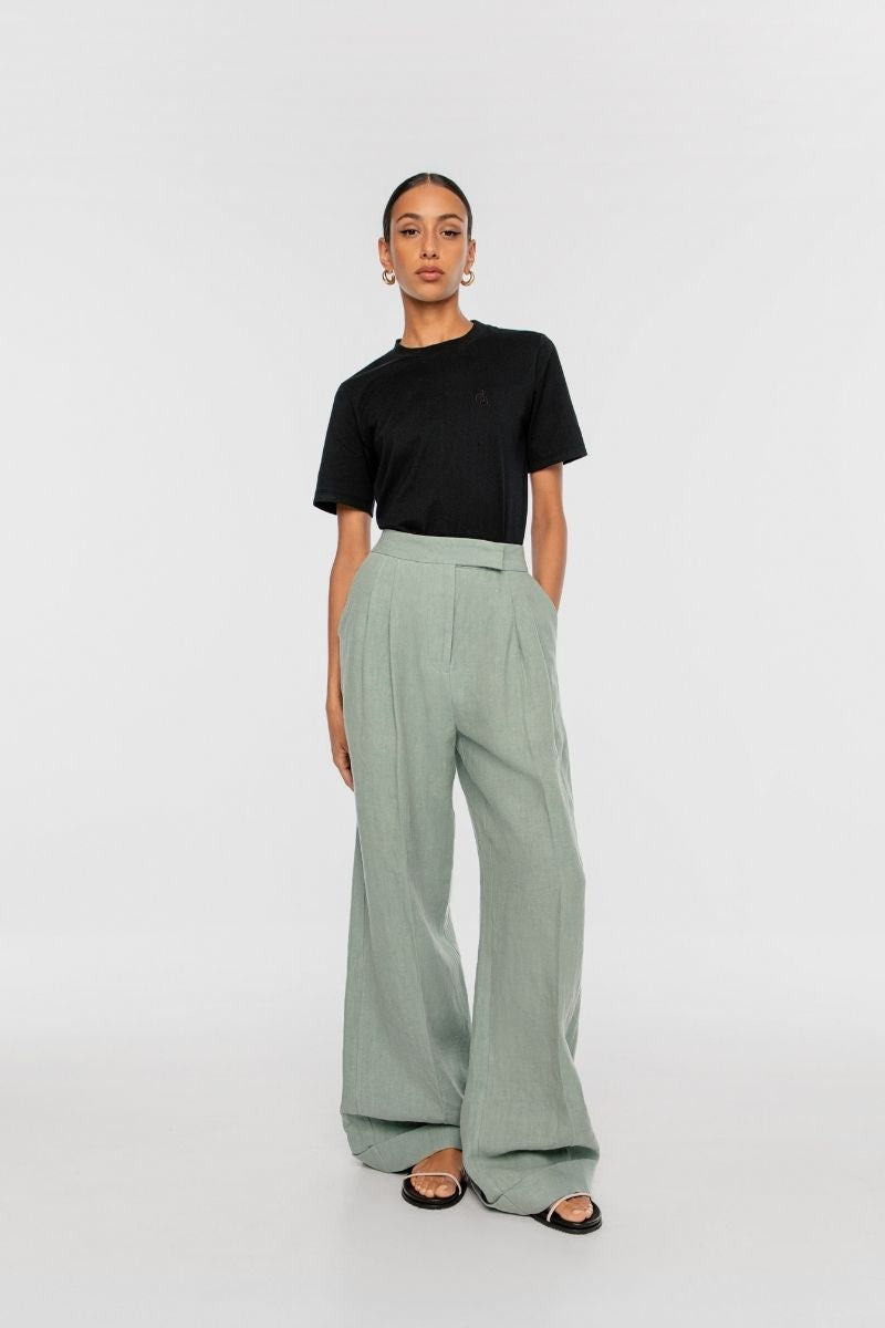 Dāl the Label linen wide leg pants in natural beige, featuring a relaxed fit and flowing silhouette on a neutral background.