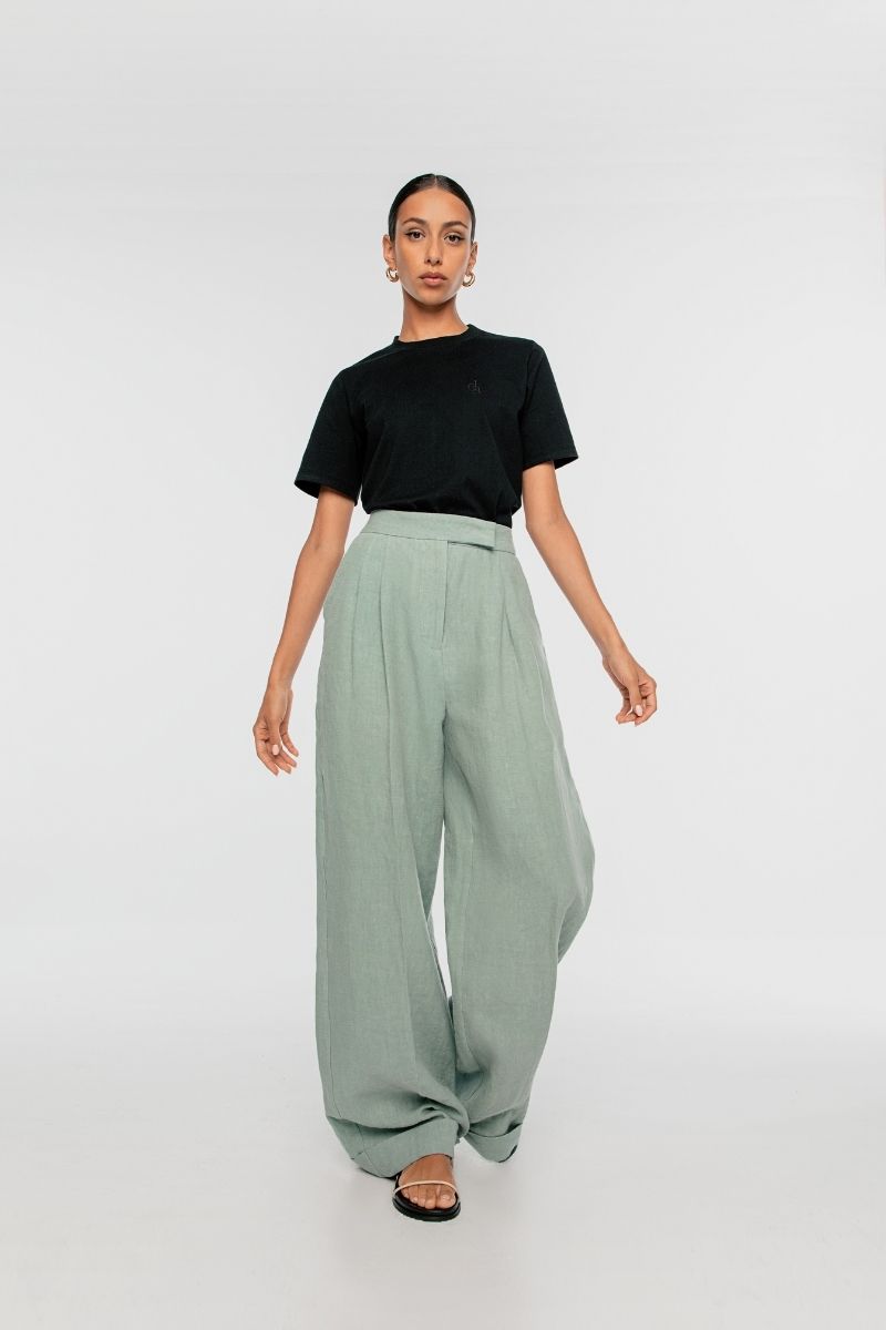 Light beige linen wide-leg pants by Dāl the Label, shown folded on a white background.