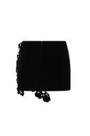 Black floral mini skirt by Levia featuring a fitted waist and playful floral pattern, perfect for casual or dressy outfits.