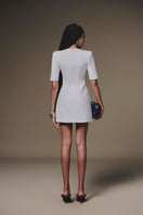 White buttoned mini dress by Keira Tong, stylish sleeveless design with a fitted silhouette and front button details.