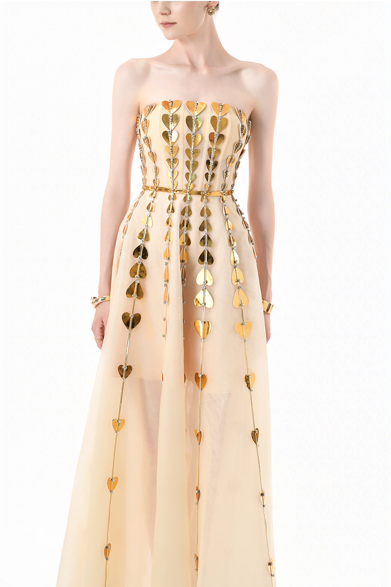 Elegant champagne metallic gown with heart embellishments by Happy Clothing, featuring a flowing design and shimmering fabric.