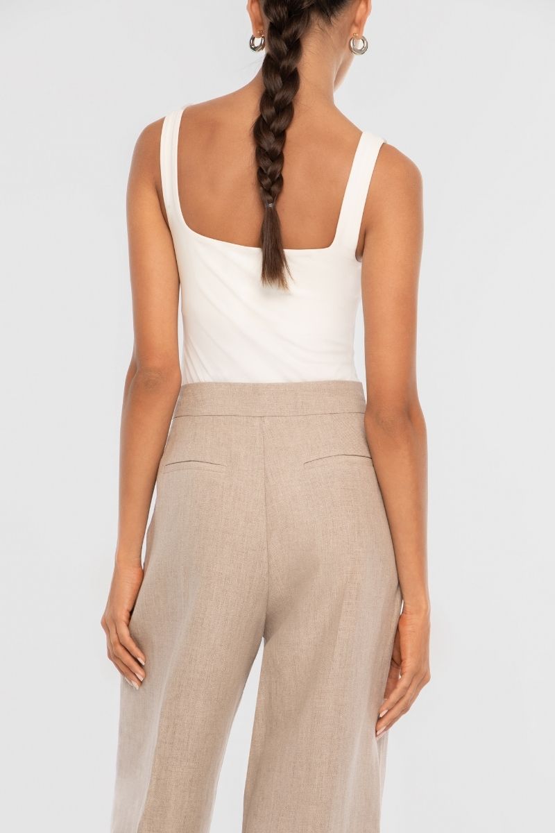 Dāl the Label linen wide-leg pants in a relaxed fit, featuring a high waist and flowing fabric, displayed on a hanger.