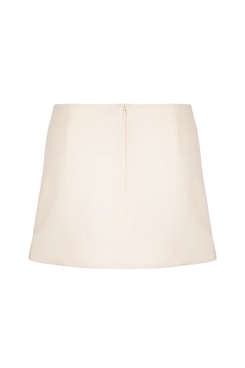 Ivory high-rise mini skirt by Nara Niro, featuring a sleek fit and stylish design, worn by a model on a casual street background.