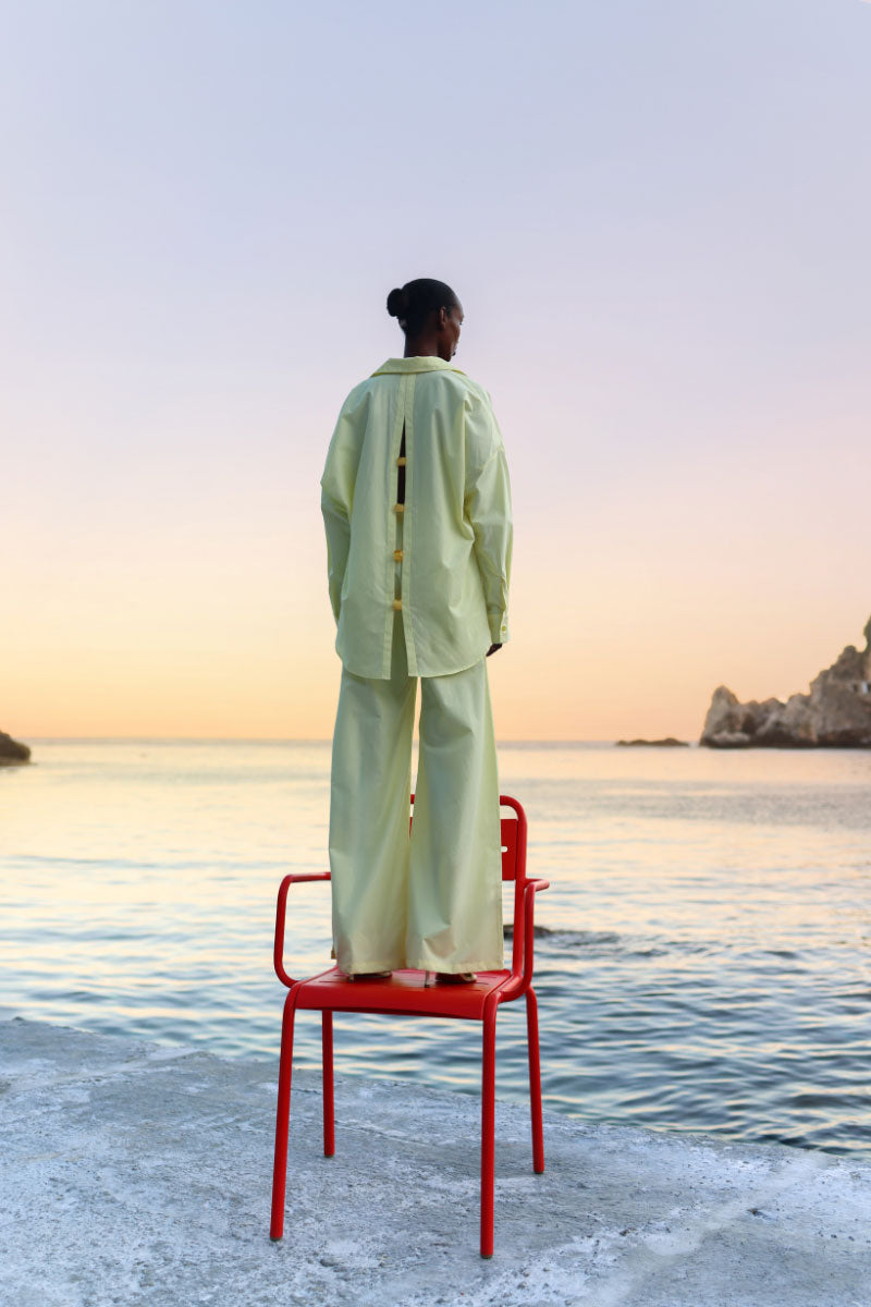 Baobab Wayra pants in limone color displayed on a model, showcasing the relaxed fit and lightweight fabric.