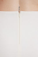 Ivory high-rise mini skirt by Nara Niro, shown on a mannequin, featuring a fitted waist and short hemline.