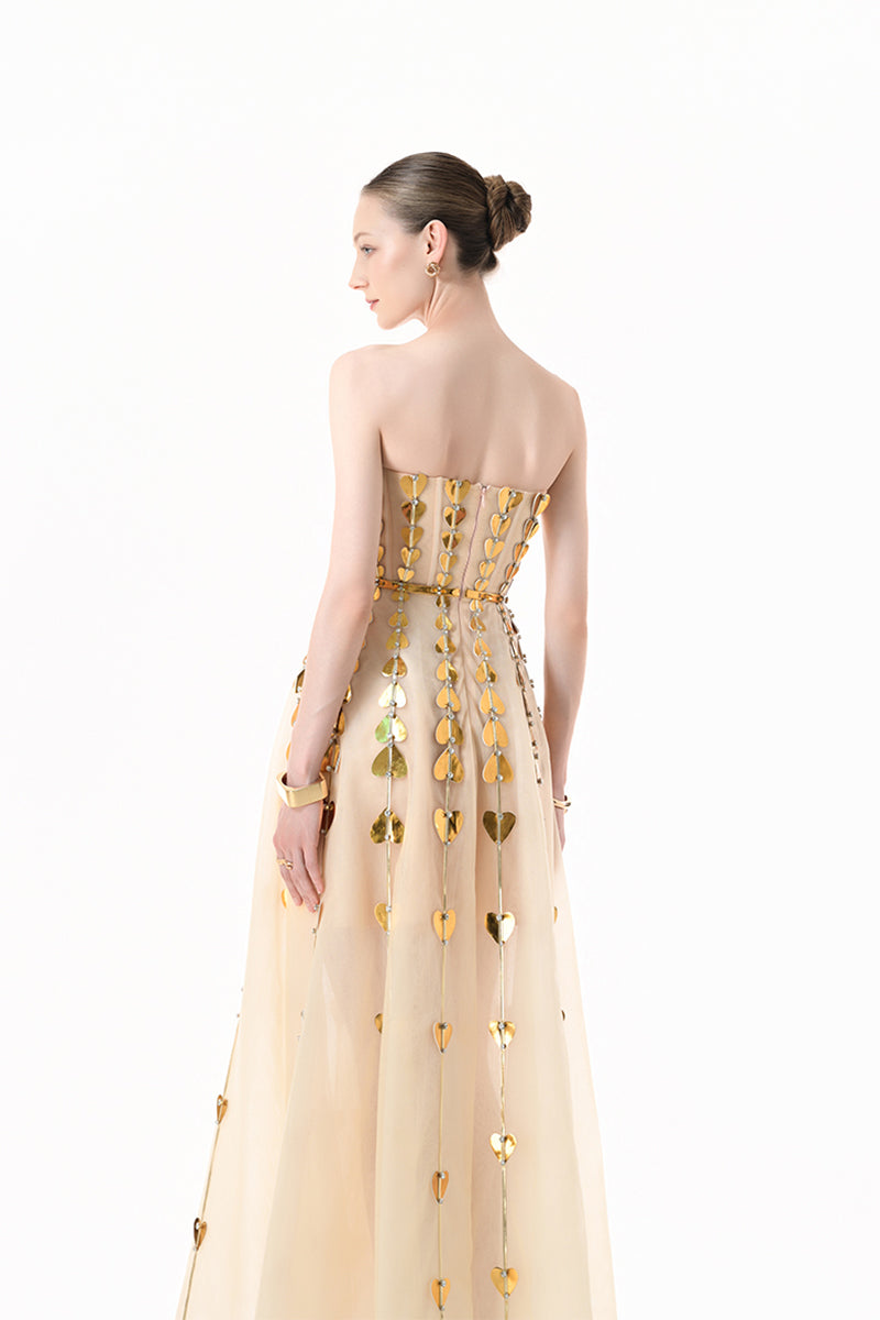 Elegant champagne metallic gown by Happy Clothing featuring heart-shaped embellishments and a flowing, glamorous design.