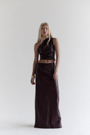ZUT Laurel Leather Maxi Skirt in black, flowing design with a smooth leather finish, positioned on a hanger.