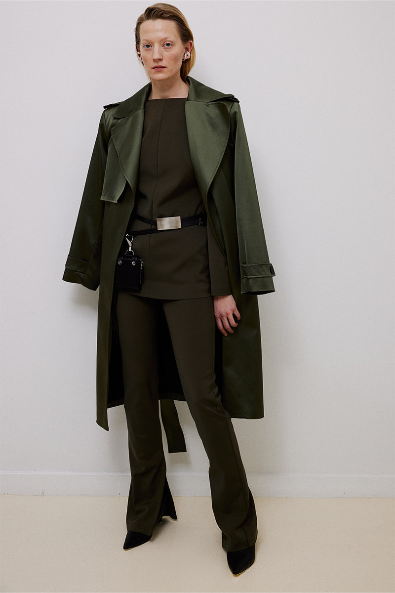 Green belted trench coat by TAGG, stylish waterproof coat with a waist belt and classic collar, suitable for rainy weather.