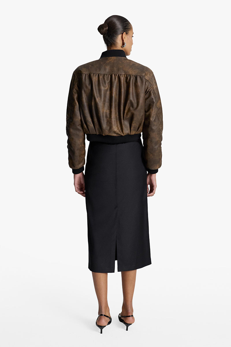 Acaria Studio Nostalgie leather bomber jacket displayed on a hanger, showcasing its classic design and rich brown leather finish.