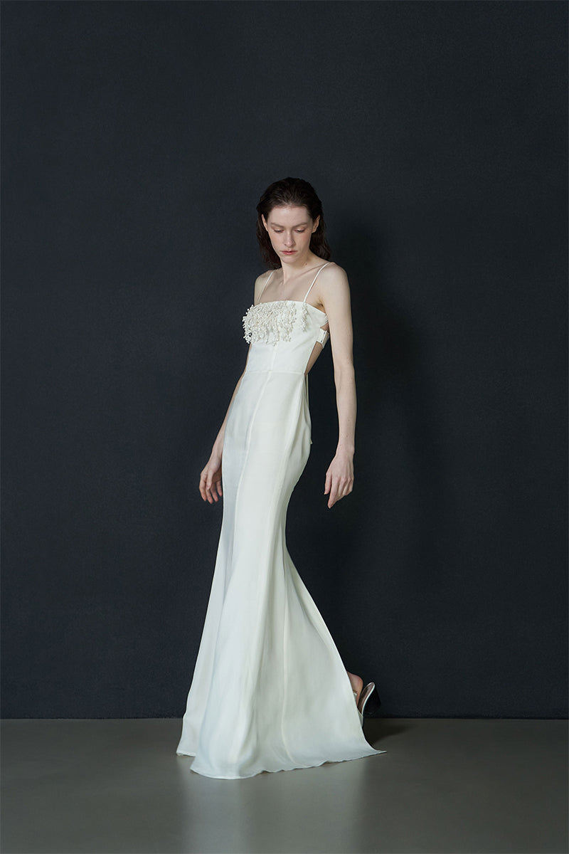 Elegant ivory gown by JINSUN with botanical embellishments, featuring flowy cupro fabric and intricate floral detailing.