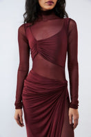 Deme By Gabriella Gloria cherry red ruched gown displayed on a hanger with elegant draping and fitted design.