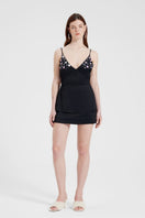 Black embroidered V-neck top by Nara Niro, featuring intricate embroidery and a stylish V-neck design, worn by a model.