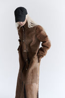 ZUT Flemington leather coat displayed on a hanger, showcasing its stylish design and rich brown leather material.