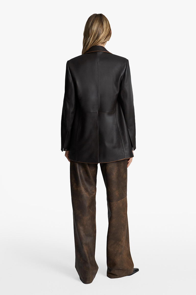 Acaria Studio root washed leather pants shown on a model, featuring a slim fit and natural leather texture.