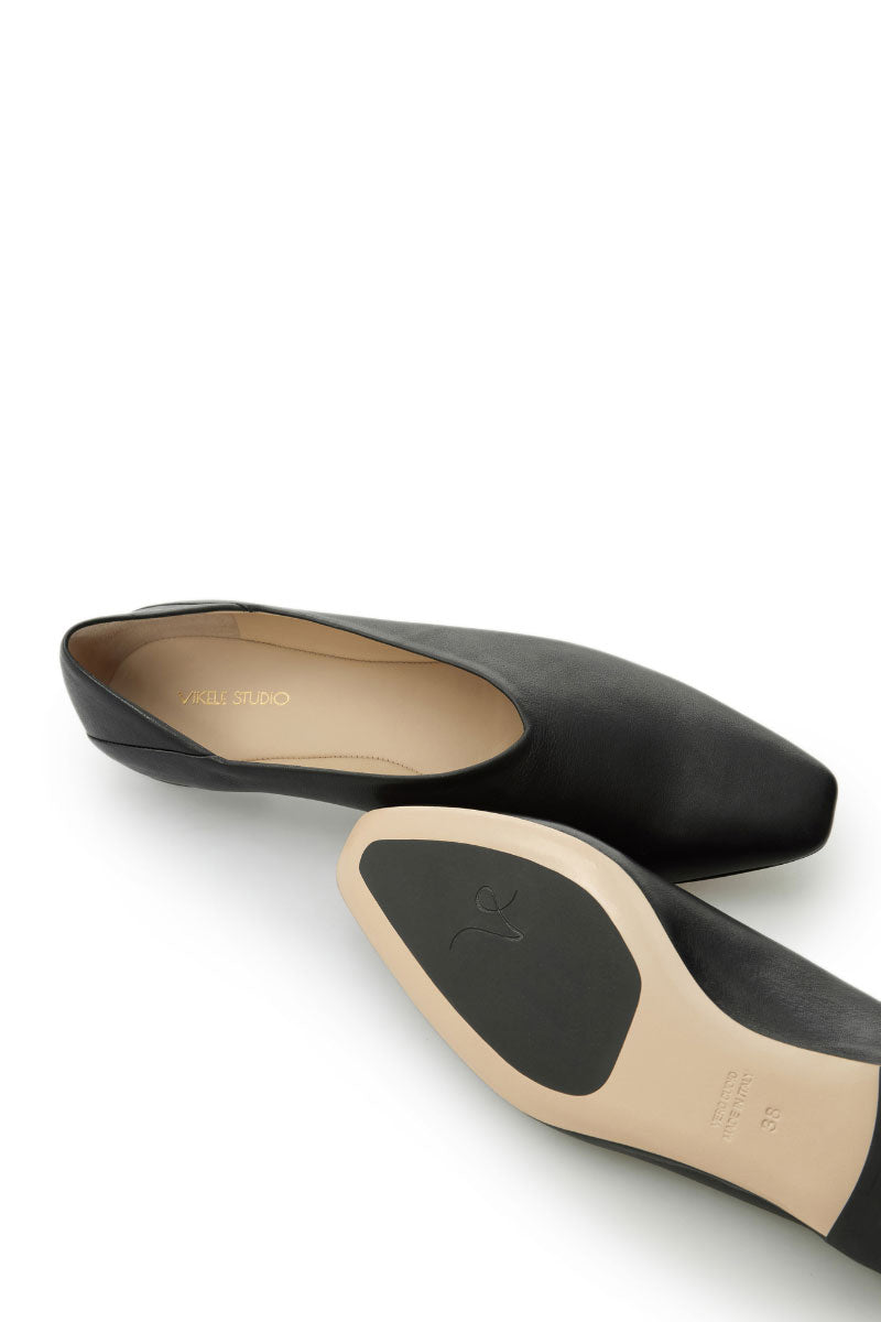 Black flats by Vikele Studio with a sleek, minimalist design, perfect for casual or professional wear.