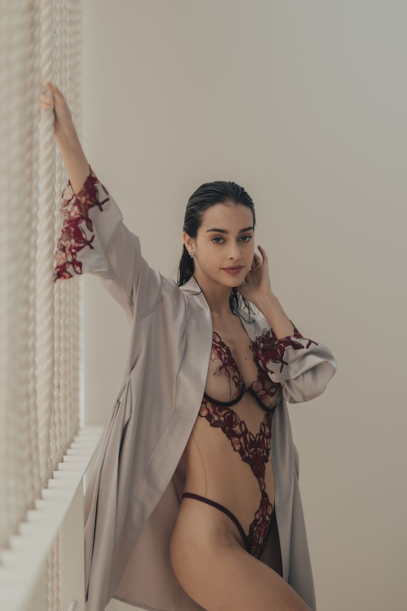 Entos OOLOG burgundy bodysuit with long sleeves and fitted design, shown on a neutral background.