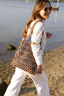 Adriana Castro leather and suede shoulder bag in blue and tan with sleek design and adjustable strap.