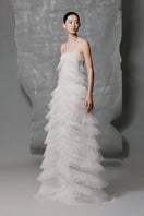 White tulle A-line gown with layered pleats and embellishments by Phan Huy, featuring a flowing, elegant design.