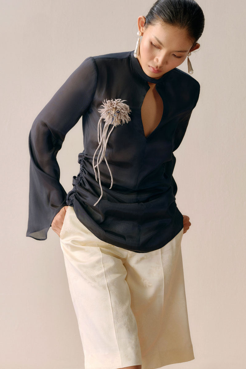 Black Leicia slit front mesh shirt, showcasing its sheer fabric, stylish front slit, and modern tops design.