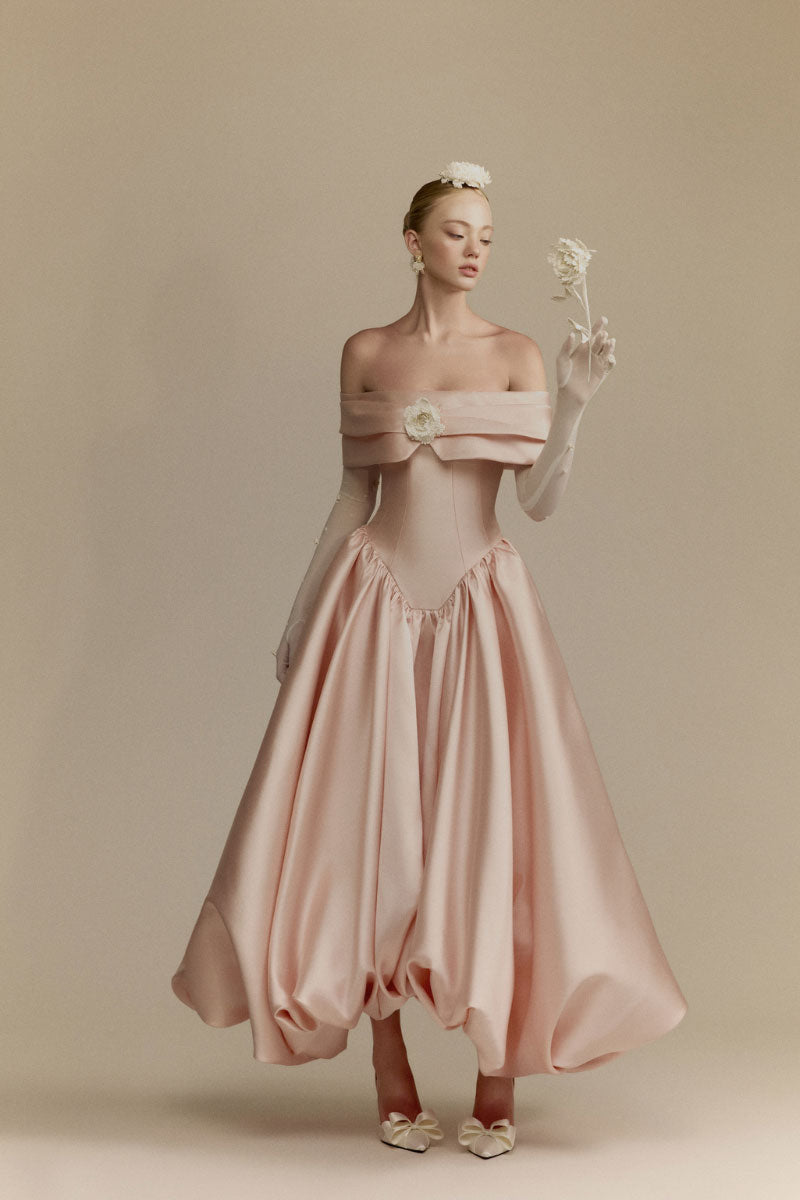 White Plan Veronica gown displayed on a hanger, showcasing its elegant design and flowing fabric.