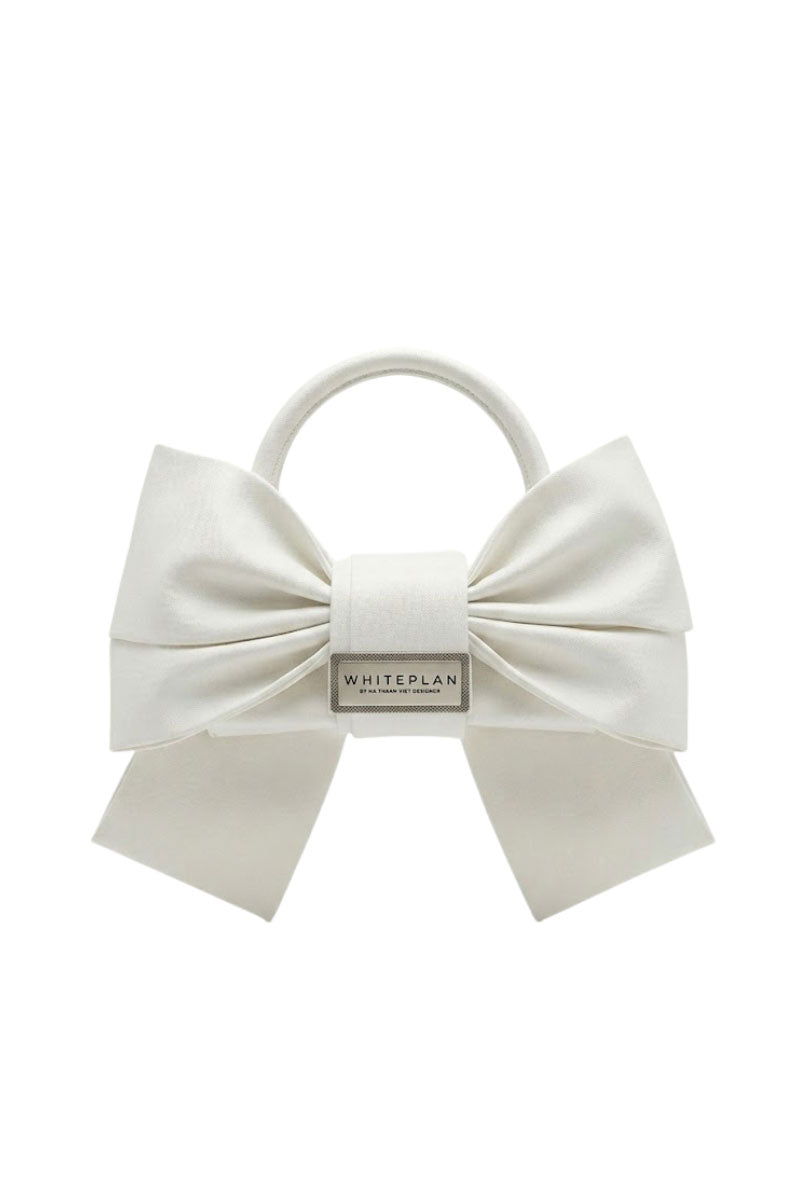 Ivory top handle bag by White Plan with bow detail, showcasing a stylish and elegant accessory for everyday use.