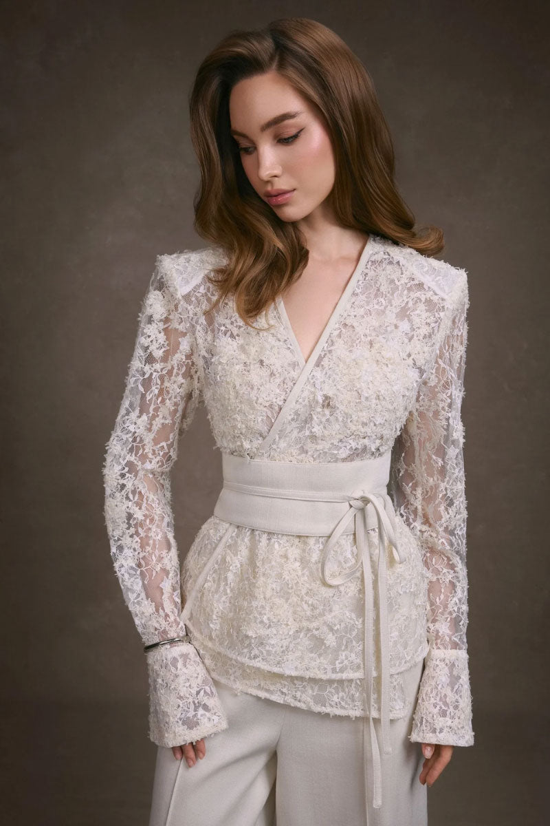 Light beige KEIRA TONG lace wrap top with delicate lace details and long sleeves, styled on a mannequin.