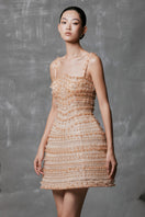 Shimmering nude mini dress by Phan Huy with fitted design and subtle sparkle, shown on a model.
